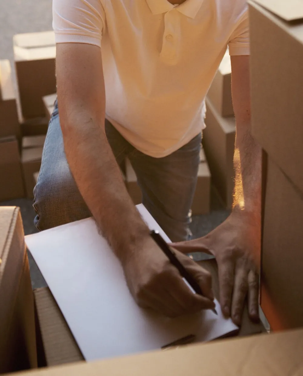 Medewerker noteert de inventaris tussen de verhuisdozen